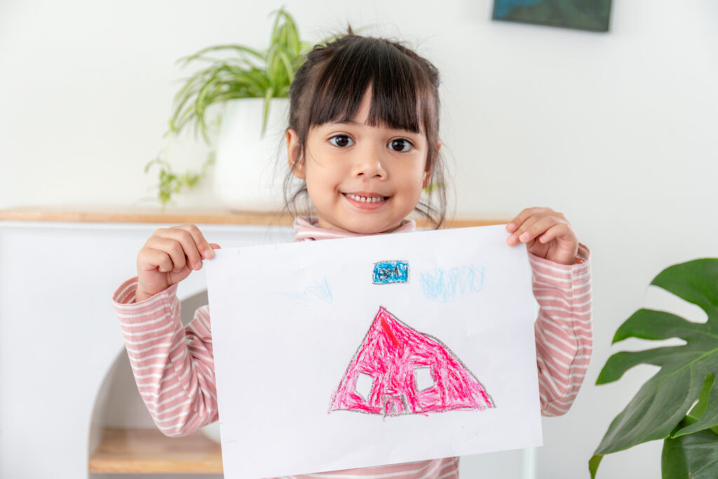 Little girl holding a drawing while her mother shops for free baby items at Alternative Care Center in Kalamazoo.